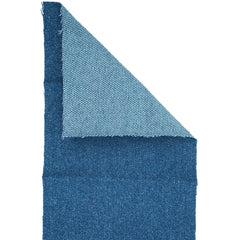 Close-up van een opgevouwen blauwe Kleiber Flexi-Patch jeans reparatiedoek, met de lijmlaag aan de bovenkant zichtbaar.