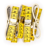Yellow and white tape measures with gold clasps, showing cm and inches. Made in Germany. MEETLINT-150-GEEL-WIT-BOX10