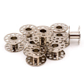 Stapel glänzender Metall-Nähmaschinenspulen mit kreisförmigen Perforationen, eine aufrecht stehend. SEWMATE-2518(B)(P) 4714379452471