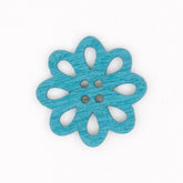 A single blue wooden flower-shaped button with cut-out petals and four holes, showing wood grain texture. KNP00082