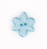 Botón azul claro transparente en forma de flor con purpurina y dos agujeros, sobre fondo blanco. KNP00013