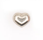A single, shiny silver heart-shaped button, 10x9mm, with a textured indentation. KNP00050-2