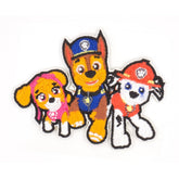Three embroidered Paw Patrol characters, Chase, Marshall, and Skye, on a white background. PAWPATROL
