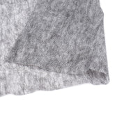 Close-up van dun, soepel grijs vlieseline met gespikkelde textuur, op witte achtergrond. PLAKVLIES-DUN-GRIJS-90X100